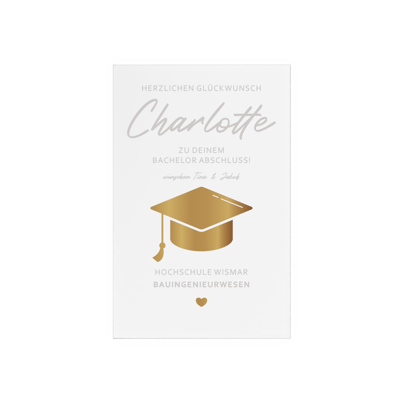 Transparenter Acrylglas-Aufsteller mit Holzsockel, personalisiert als Geschenk zum Abschluss. Zeigt goldene Doktorhut-Grafik, Namen, Studiengang und Hochschule in elegantem Design.