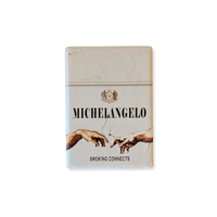 Rechteckiger Keramik-Kühlschrankmagnet (7x5 cm) mit seidenmatter Glasur im Design einer hellen Vintage-Zigarettenschachtel. Abgebildet sind Michelangelos Hände, die eine Zigarette weitergeben, mit dem Schriftzug 'MICHELANGELO SMOKING CONNECTS' im fühlbaren 3D-Relief.