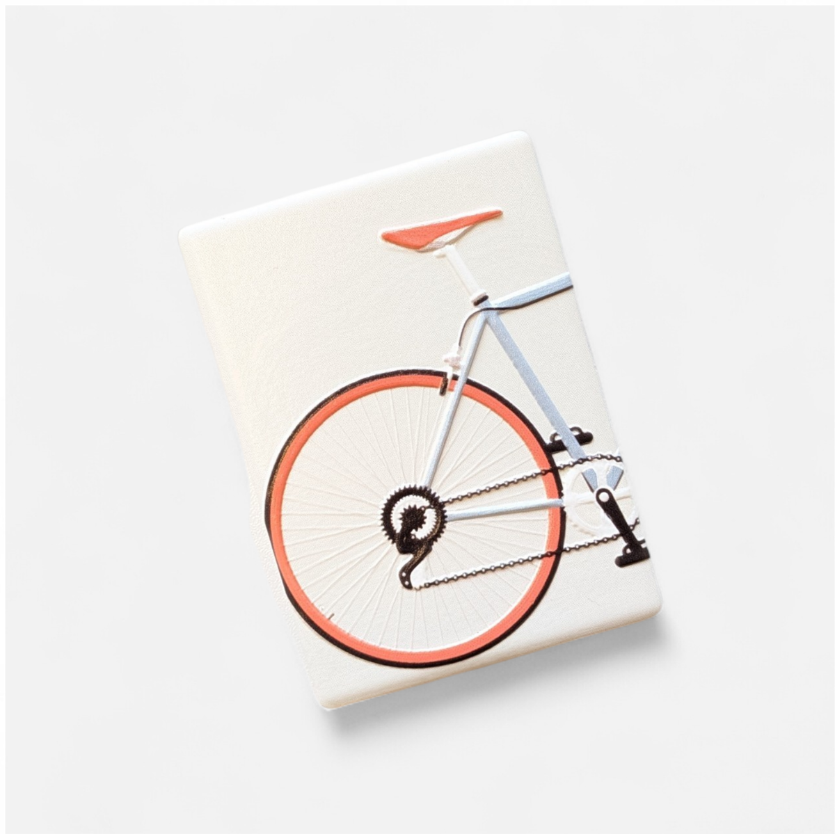 Rechteckiger Keramikmagnet mit einer detaillierten Illustration eines Rennfahrers auf einem Rennrad. Seidenmatte weiße Oberfläche mit haptischem Relief der Rad-Konturen im Vintage-Stil.