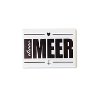 Rechteckiger Keramik-Kühlschrankmagnet (7x5 cm) im Querformat mit seidenmatter Glasur. Auf weißem Grund steht der schwarze Schriftzug 'etwas MEER' mit Anker und Herz-Symbol im fühlbaren 3D-Relief.