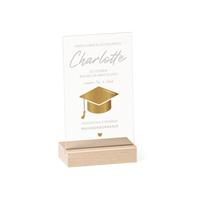 Transparenter Acrylglas-Aufsteller mit Holzsockel, personalisiert als Geschenk zum Abschluss. Zeigt goldene Doktorhut-Grafik, Namen, Studiengang und Hochschule in elegantem Design.