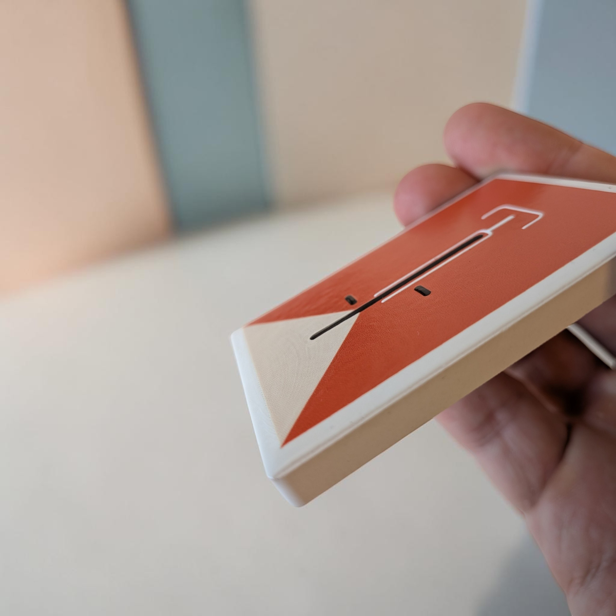 Rechteckiger, weißer Kühlschrankmagnet aus Keramik mit einem minimalistisch dargestellten Fahrrad in kräftigem Orange im Zentrum. Das Design ist schlicht, modern und sauber.