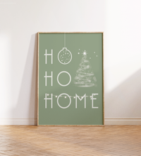 Minimalistisches Weihnachtsposter mit dem Schriftzug ‚Ho Ho Home‘ in Grün oder Schwarz, dekoriert mit Weihnachtsbaum, Kugel und Girlande – gedruckt auf hochwertigem Fineart-Papier.