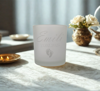 Frostweißes Teelichtglas mit individueller Gravur von Name und Geburtsdatum, darunter zwei Babyfüße – liebevolles Geschenk zur Geburt oder Erinnerung an Sternenkinder.