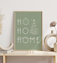 Minimalistisches Weihnachtsposter mit dem Schriftzug ‚Ho Ho Home‘ in Grün oder Schwarz, dekoriert mit Weihnachtsbaum, Kugel und Girlande – gedruckt auf hochwertigem Fineart-Papier.