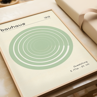Das Poster im Bauhaus-Stil  zeigt dir eine Spirale im Kreis in Grün oder Orange.