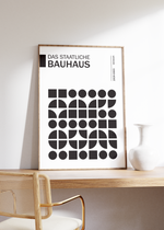 Dieses Bauhaus Poster zeigt dir verschiedene Schwarz dargestellte, geometrische Formen. Das in schönem Schwarz und Weiß gehaltene Poster hat die Bildüberschrift "Das Staatliche Bauhaus" 