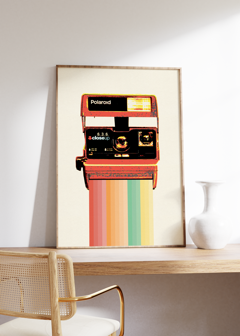 Das Poster zeigt eine alte Polaroidkamera mit einem Regenbogen als Bildausgabe. 