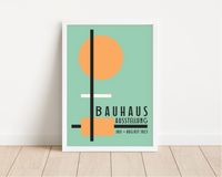 Das Bauhaus Poster zeigt dir unterschiedliche geometrische Formen in Orange, Schwarz und Weiß auf blauem Hintergrund. Das Poster ist einem Ausstellungsplakat von 1923 nachempfunden, ist so aber nie erschienen. 