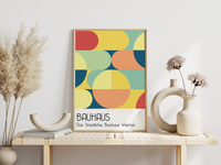 Dieses Bauhaus Poster zeigt dir verschiedene geometrische Formen die bunt dargestellt sind. Das in schönem Blau- und Rottönen gehaltene Poster hat die Bildunterschrift Das Staatliche Bauhaus
