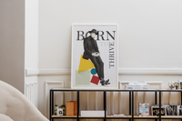 Das Fashion-Poster zeigt einen Mann im Anzug und mit Hut, sitzend auf verschiedenen geometrischen Formen.