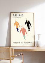 Das Bauhaus Poster zeigt drei geometrisch dargestellte Herren in verschiedenfarbigen Anzügen mit Hut und Einstecktuch. Das Poster, mit der Bildüberschrift Bauhaus Ausstellung und der Unterschrift Führend in der Herrenmode, Sütterlin, Badenerstrasse 109,  ist einem Ausstellungsplakat nachempfunden, ist so aber nie erschienen.